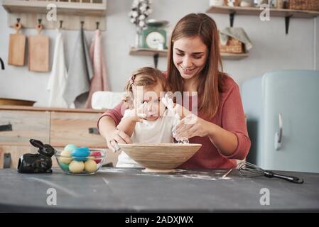 Vorbereiten der Mehl. Mutter lehrt Tochter die Eier für das Osterfest zu malen Stockfoto