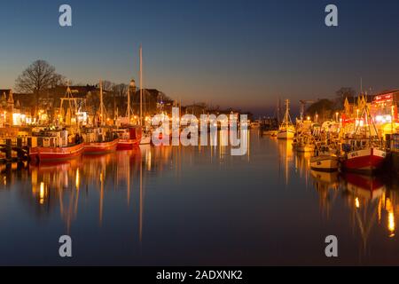 Traditionelle Fischerboote in den Kanal der Alte Strom/Alte Kanal bei Warnemünde in der Stadt Rostock in der Dämmerung, Mecklenburg-Vorpommern, Deutschland Stockfoto