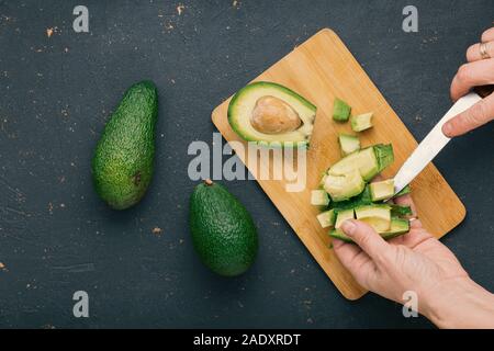 Frau Scheiben Avocado. Avocado Salat Rezept Stockfoto