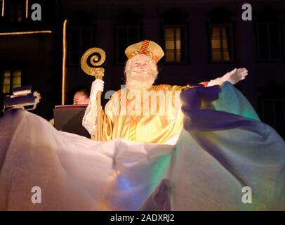 Ljubljana, Slowenien. Dez 2019. Der heilige Nikolaus, begleitet von Teufeln und einer Engelsversammlung, geht durch die Altstadt von Ljubljana zur Kirche der Verkündigung. Nach slowenischer Tradition bringen Engel gute Kinder mit Geschenken, während die Teufel die Frechen verschenken. Die jährliche traditionelle Veranstaltung findet am Vorabend des Nikolaus-Tages statt und umfasst die Verteilung von Keksen, Obst und Süßigkeiten an Kinder. Stockfoto