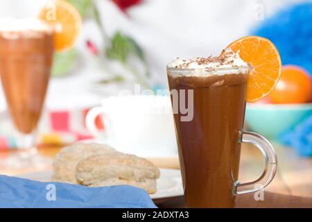 Heiße Schokolade trinken im hohen Glas mit Orange Slice und Rahm Stockfoto