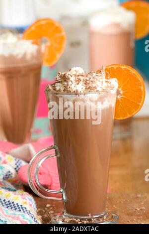Hot chcolate Drink in hohes Glas mit Orange Slice und Schlagsahne Stockfoto