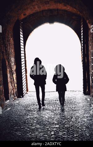 Junger Mann und Frau gehen durch einen Tunnel passage Stockfoto