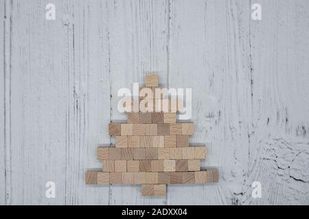 Weihnachtsbaum aus kleinen Holzwürfeln auf Holzbrett Stockfoto