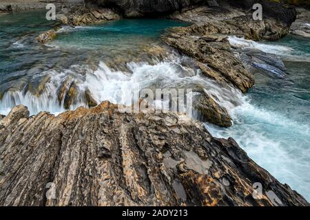 Den Kicking Horse River fließt von den Bergen herab, wurde zu einem Wasserfall, bevor es unter einer natürlichen Brücke geht, Yoho National Park, British Columbi Stockfoto