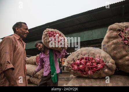 (191205) - NEW DELHI, Dez. 5, 2019 (Xinhua) - eine Arbeit trägt einen Sack Zwiebeln in einem Großhandelsmarkt in Neu-Delhi, Indien, am Dez. 5, 2019. Die Zwiebel Preise in indischen Staaten weiterhin als Regierung zu steigen an, versprach die essbaren Knollen aus dem Ausland zu importieren. (Xinhua / Javed dar) Stockfoto