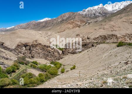 Pamir Highway von alichur zu Karadara Khargush mit Blick auf die River Tal und die schneebedeckten Berge an einem sonnigen blauen Himmel Tag Stockfoto