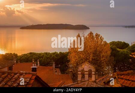 Schönen Sonnenuntergang über Passignano historische Zentrum mit Isola Maggiore (Insel) im Trasimenische See Stockfoto