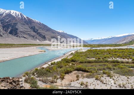 Pamir Highway Wakhan Korridor mit panj River Valley und in Afghanistan die schneebedeckten Berge an einem sonnigen blauen Himmel Tag Stockfoto