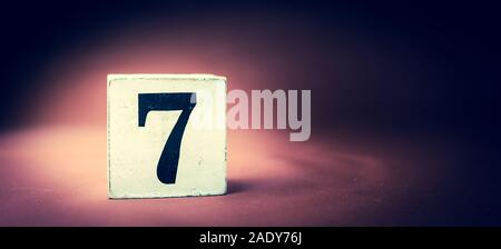 Alte vintage Holzblock mit der Ziffer 7, Nummer sieben - lebendige maroon Hintergrund Stockfoto