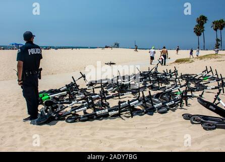 Polizisten wartet Sicherheitsvorschriften für Elektroroller durchzusetzen und beschlagnahmt Viele in Venice Beach, Kalifornien Stockfoto