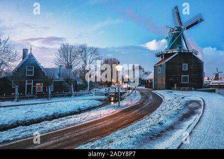 Kleine Mühle und typische Häuser auf dem zaans Zaanse Schans im Winter auf dem Fluss De Zaan in den Niederlanden Stockfoto