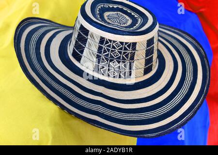 Der ombrero vueltiao" (traditionelle Hut aus Kolumbien) mit kolumbianischen Flagge als Hintergrund Stockfoto