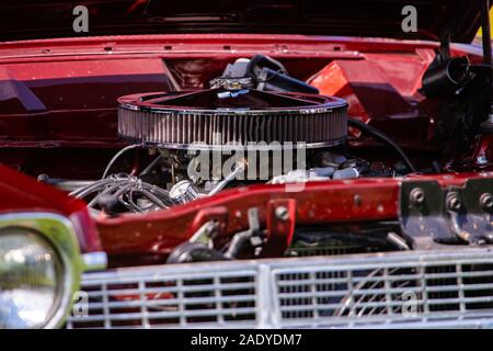 Selektiver Fokus der großen verchromten runde Luftansaugfilter auf einem roten classic Muscle Car, American Motor Teile nähe zu sehen. Stockfoto