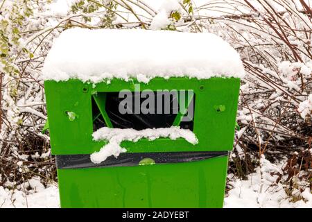 Müll kann in Grün für Hundekot mit Schnee Stockfoto