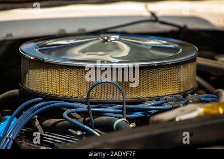 Close Up und selektiven Fokus auf großen verchromten runde Luftansaugfilter auf einem klassischen Muscle Car Motor, mit blauen Drähte, Zündkabel Stockfoto