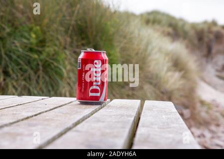 Dude kann der Drink am Strand mit Sand und Gras im Hintergrund Stockfoto