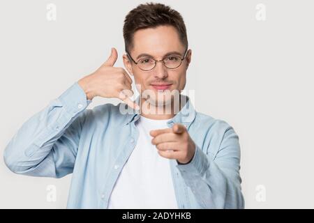 Glücklich lächelnde junge Kerl in Brillen, rufen Sie Geste. Stockfoto