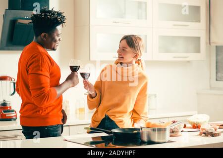 Entspannt Ehepaar miteinander reden, in der Küche und glockengebimmel Gläser Stockfoto