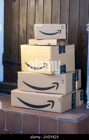 Stapel von Amazon Prime Kästchen links auf einer Türschwelle Stockfoto