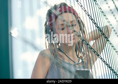 Ruhe langhaarige Dame denken und Ihr Gadget Stockfoto