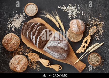 Hoher Ballaststoffgehalt deutsche Roggenbrot Brot mit Sauerteig und gesätes Brötchen, lose Körner und Samen. Hohe an Vitaminen, Antioxidantien und Omega 3. Stockfoto