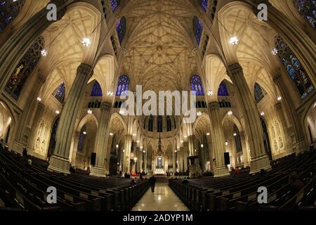 New York City, NY - November 20, 2019: Nicht identifizierte Personen sitzen und laufen innerhalb des St. Patrick Kirche befindet sich in der 5th Avenue in Manhattan New Stockfoto