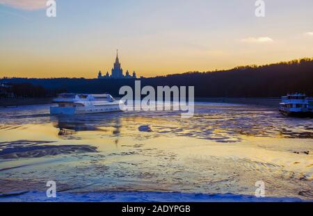 Freude Schiff bei Sonnenuntergang. Der Moskauer Staatlichen Univercity für den Hintergrund. Moskau Fluss durch Eis gefangen. Stockfoto