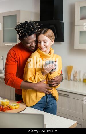 Schönes Paar umarmen in der Küche und friedlich lächelnden Stockfoto