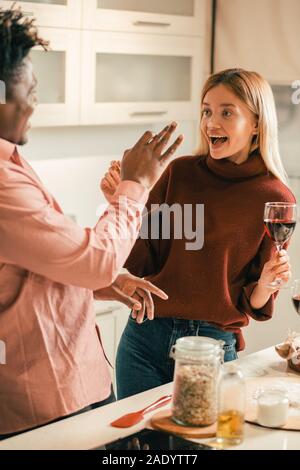 Aufgeregt Frau mit einem Glas Wein und Mann mit ihr spielen Stockfoto