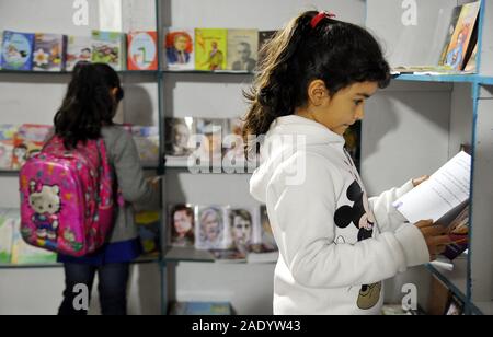 Damaskus, Syrien. 5 Dez, 2019. Mädchen Bücher lesen während einer Buchmesse für Kinder in Damaskus, Syrien, Dez. 5, 2019. Die syrischen Ministerium für Kultur hielt eine Buchmesse für Kinder am Donnerstag. Credit: Ammar Safarjalani/Xinhua/Alamy leben Nachrichten Stockfoto