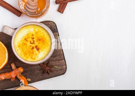 Gelbwurz latte und Gewürze über weiße Holz- Hintergrund Stockfoto