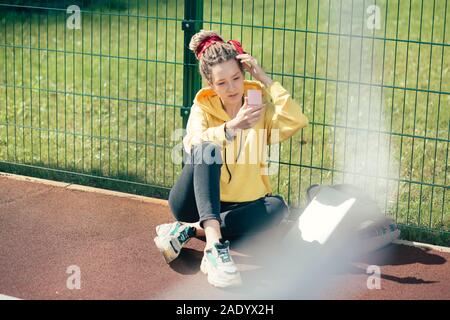 Die ganze Länge der jungen Dame an ihr Spiegelbild im Spiegel zu betrachten Stockfoto