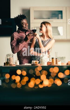 Romantische Atmosphäre in der Küche und Paar beim Rotwein Stockfoto