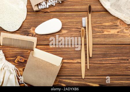 Null Abfall Home Produkt. Bambus Zahnbürsten, Seife, Wattestäbchen Holzstäbchen auf Holz- Hintergrund. Natürliche Pflegeprodukte. Flach mit Kopie Raum Stockfoto