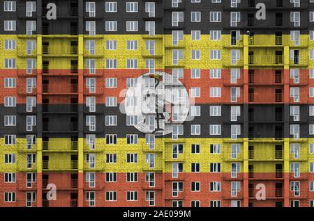 Uganda Fahne in Farbe Farben auf multi-Geschichte residental Gebäude im Bau. Texturierte Banner auf große Mauer Hintergrund Stockfoto