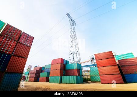 Stapler anheben Cargo Container in der Schifffahrt Yard oder Dock Yard gegen Sonnenaufgang Himmel mit Cargo Container im Hintergrund für den Transport Stack i Stockfoto