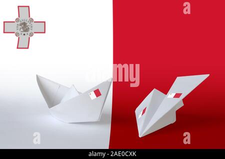 Malta Flagge auf dem Papier origami Flugzeug und Schiff dargestellt. Orientalische Handarbeit Kunst Konzept Stockfoto