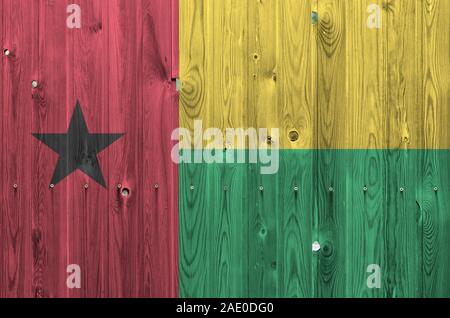 Guinea Bissau Flagge in hellen Farben dargestellt auf alte hölzerne Wand hautnah. Texturierte Banner auf rauen Hintergrund Stockfoto