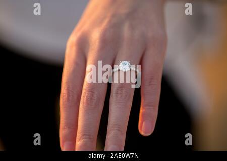 Verlobungsring auf der Frau Hand bei Sonnenuntergang Stockfoto