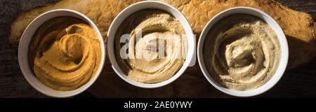 Blick von oben auf die Köstliche sortierten Hummus auf frisch gebackene Pita, Panorama-Aufnahme ein. Stockfoto