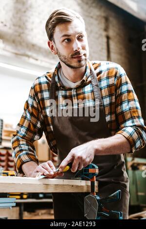 Stattliche Tischler holding Meißel Beim schnitzen Holz in der Werkstatt Stockfoto