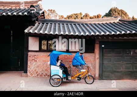 DEC 13, 2016 in Seoul, Südkorea - Touristen und Pedicap Rikscha Tour im schönen vintage Bukchon Hanok alten lokalen Dorf. Stockfoto