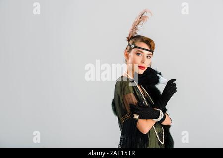 Aristokratische Frau in Schwarz Handschuhe holding Federfächer isoliert auf Grau Stockfoto