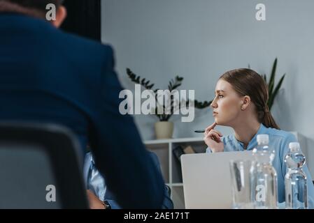 Aufmerksame Geschäftsfrau hören Kollegen während der Sitzung im Büro Stockfoto
