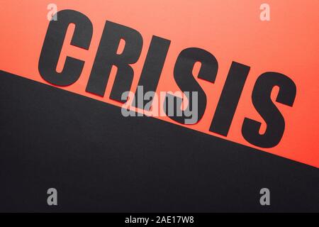 Draufsicht auf das Wort Krise auf schwarzem und rotem Hintergrund von schräge Linie geteilt Stockfoto