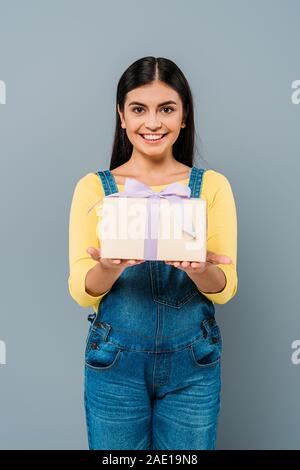 Lächelnd schwanger hübsches Mädchen Betrieb vorhanden isoliert auf Grau Stockfoto