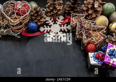 Weiten Bogen Weihnachten Dekoration geprägt. Zweige Weihnachtsbaum, Braun Natur Tannenzapfen und und Xmas Hirsch mit Vielzahl von Obst auf dunklen backgrou Stockfoto