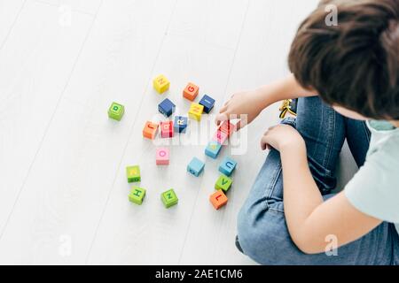 7/8-Ansicht von Kid mit Legasthenie spielen mit bunten Bausteinen Stockfoto