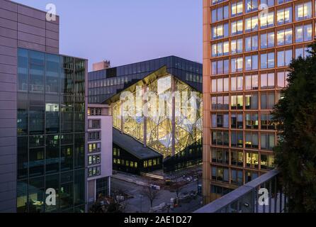 Berlin, Deutschland. 05 Dez, 2019. Die Axel Springer neues Gebäude am Abend in der Dämmerung, von einer Dachterrasse. Auf der linken Seite der Axel-springer-Hochhaus. Nach der Fertigstellung, getöntes Glas Oberflächen und 3D-Elementen wird die Fassade der Licht durchfluteten Büro Gebäude charakterisieren. Eine neue Axel Springer SE Verlagshaus ist errichtet auf dem 10.000 Quadratmeter großen Gelände. Das Gebäude bietet Arbeitsplätze für bis zu 3500 Mitarbeiter. Foto: Jens Kalaene/dpa-Zentralbild/ZB/dpa/Alamy leben Nachrichten Stockfoto
